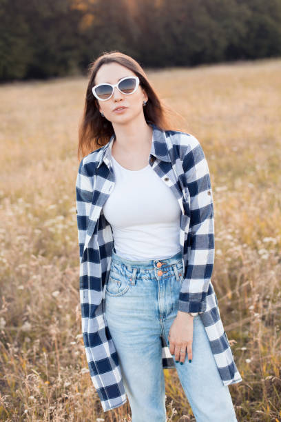 Young woman in sunglasses walking on the autumn field.