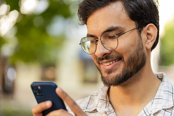 istock Hispanic young man uses smartphone typing text messages in social media application online on street 2197502868