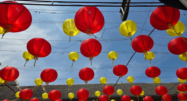 istock Vibrant red and yellow lanterns suspended across open balconies under a serene blue sky, representing festive celebrations of chinese new year and traditional cultural decor 2197507345
