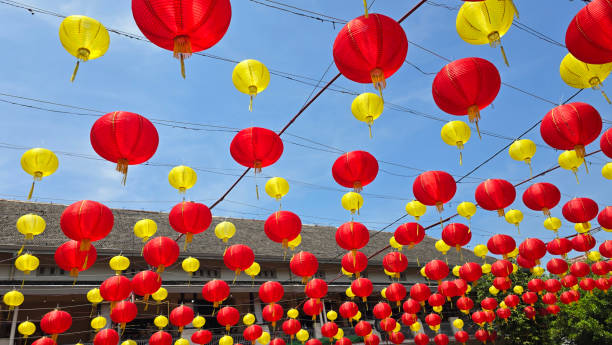 istock Vibrant red and yellow lanterns suspended across open balconies under a serene blue sky, representing festive celebrations of chinese new year and traditional cultural decor 2197507355