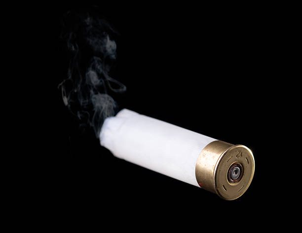 istock White shotgun shell with smoke flying through the air on black 2197518060