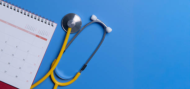 istock Stethoscope with calendar page date on blue background 2197518111