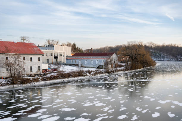 Small town by the water in winter in USA with ice in the river
