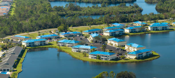 istock Hurricane damaged apartment buildings rooftops covered with protective plastic tarp against rain water leaking until replacement of asphalt shingles. Aftermath of natural disaster 2197522373