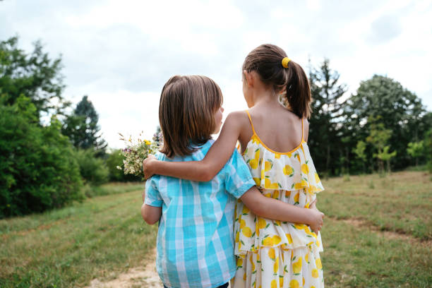 istock Two Children Enjoying Nature with Flowers Together 2197534292