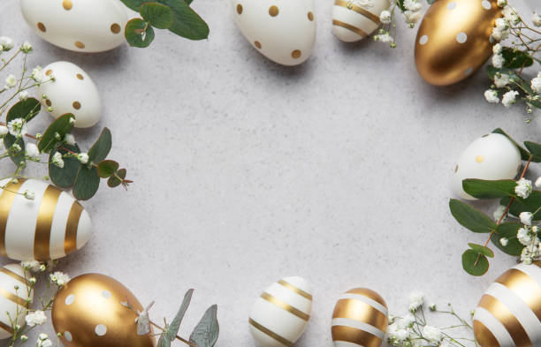istock Easter eggs with gold and white decorations forming a frame on a gray background 2197536502