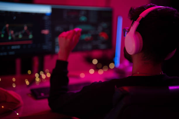 istock Engaged gamer enjoying an immersive experience in a vibrant room while using headphones and editing software at night 2197537271