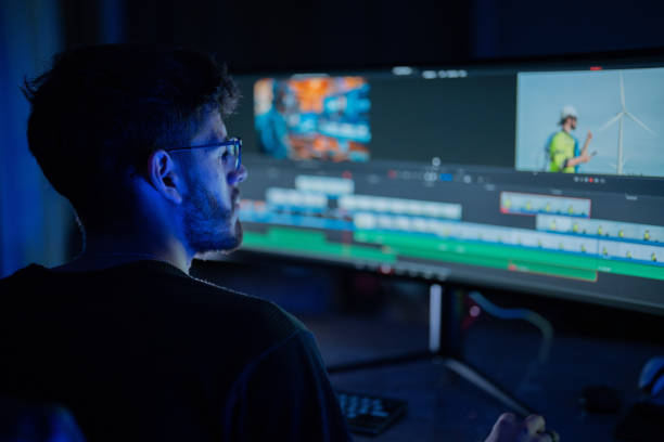 istock Young editor focuses on video clips while working late at night in a modern editing suite 2197537469