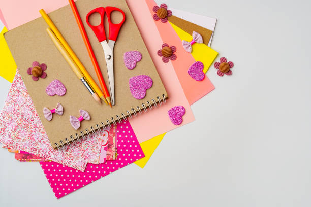 istock Crafting supplies arranged on a white surface with colorful paper and decorative items for creative projects 2197539350