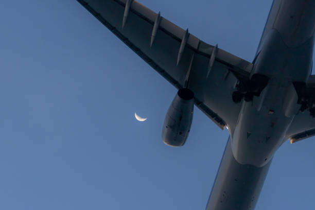 Crescent moon on blue sky with airplane.Phuket Island, Thailand.