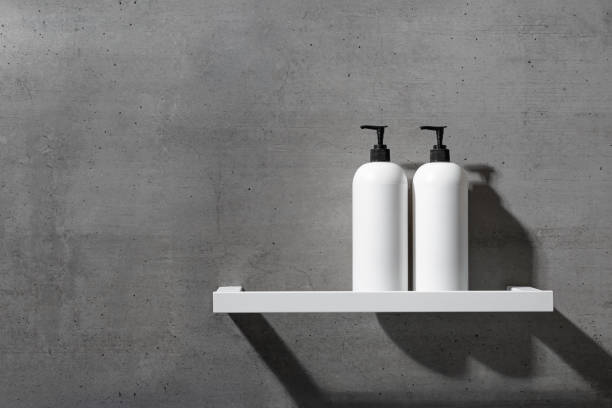 istock Two minimalist white bottles with black pump caps on white shelf against texture gray concrete background. Neutral tones minimalist interior design bathroom. Skincare, body care, beauty products 2197541372