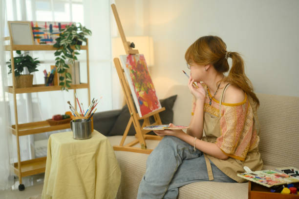 istock Thoughtful artist contemplating her work in a cozy home studio 2197542862