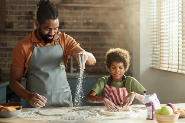 istock Happy black father and son making a cake in the kitchen. 2197546934