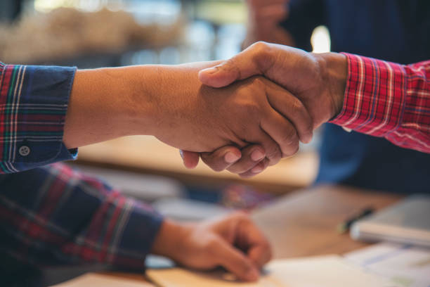 istock Civil Construction engineer teams shaking hands together wear work helmets worker on construction site. Foreman industry project working engineer teamwork. Two asian engineer team shake hands together 2197548201