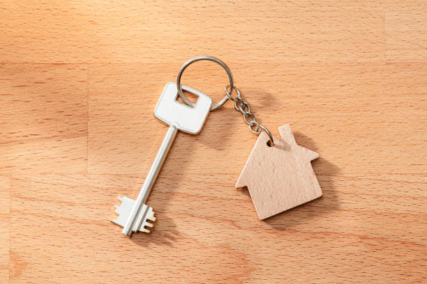 Key on a ring with house keychain on wood surface. High resolution 42Mp studio digital capture taken with Sony A7rII and Sony FE 90mm f2.8 macro G OSS lens