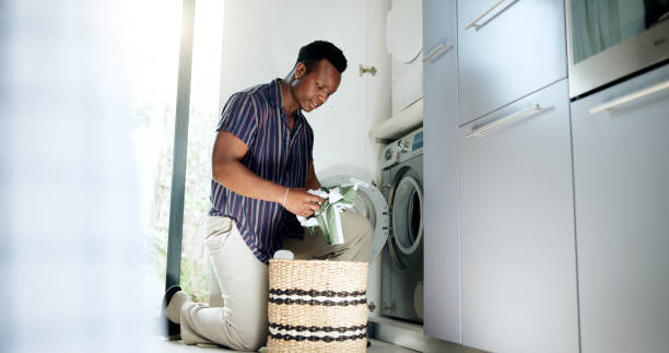 istock Laundry, African man and clothes basket with washing machine, housekeeping and cleaning routine for linen. Hygiene, black person and fabric in appliance for domestic chores and housework in washroom 2197554764