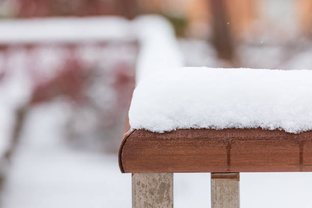 Snow piled up on the railing in the park.