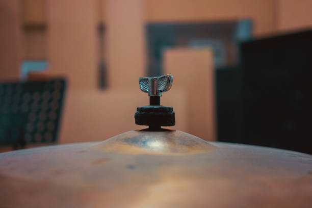 A close-up of the top of the cymbal, in the background in the blur of the rehearsal room.