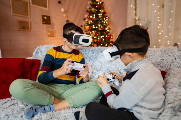 istock Two brothers playing videogames wearing vr headsets at christmas time 2197556177