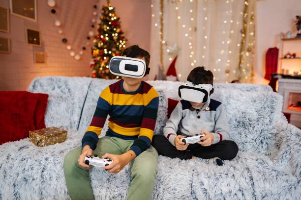 istock Two brothers playing videogames wearing virtual reality headsets at christmas time 2197556186