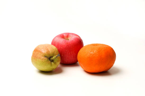 Natural texture of citrus peel and apple skin of fresh fruits close-up in a wooden bowl