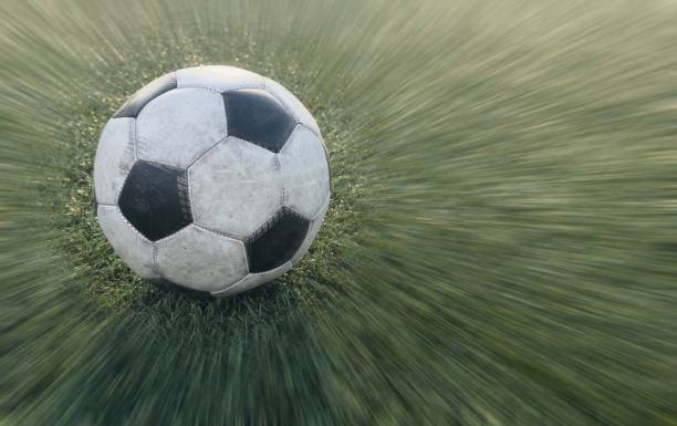 Male soccer player dribbling with ball.