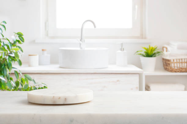 istock Marble round podium and table for product display on blurred bathroom window interior background 2197557778