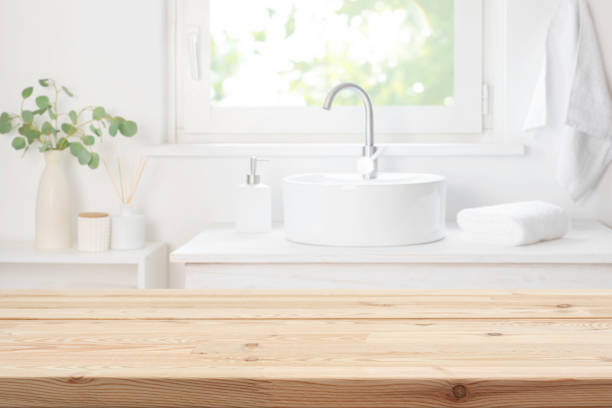 istock Rustic blur bathroom sink and window interior background with wooden table top in front 2197557793