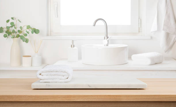 istock Stone tray with white towel on empty wooden table top in blur bathroom sink interior background 2197557837