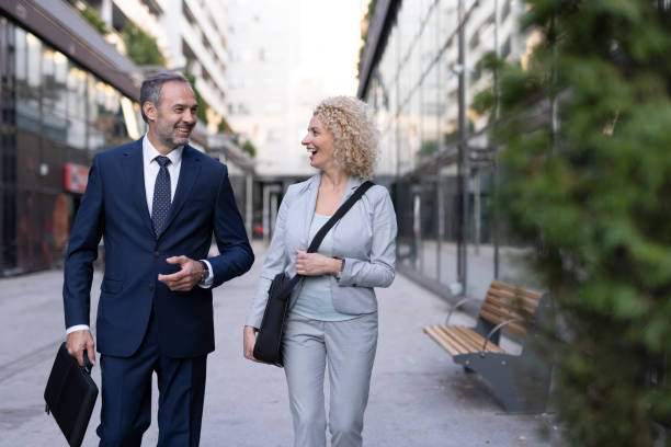 Business professionals walking and smiling outdoors together