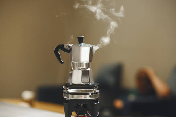 Steam Rises From Bubbling Moka Pot While Brewing Rich Coffee