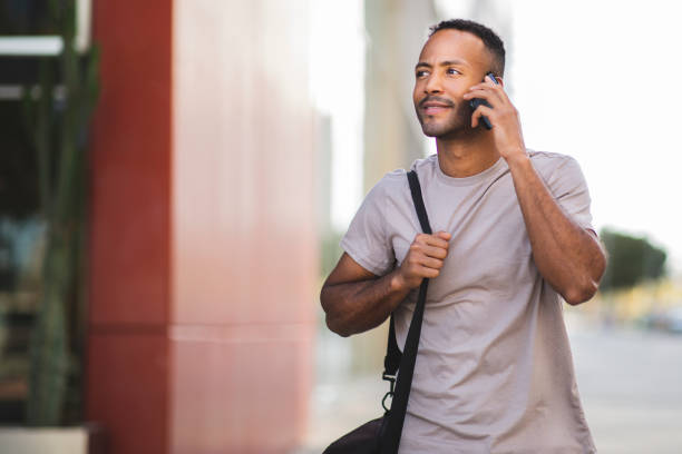 istock Man with bag talking on mobile phone 2197562153