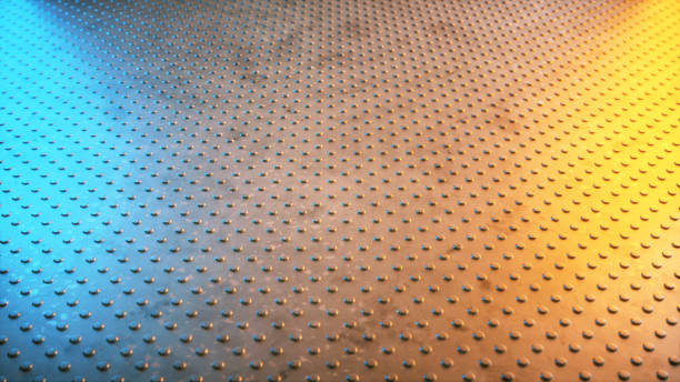 Studded industrial metal surface floor with diminishing perspective illuminated with an orange and blue light