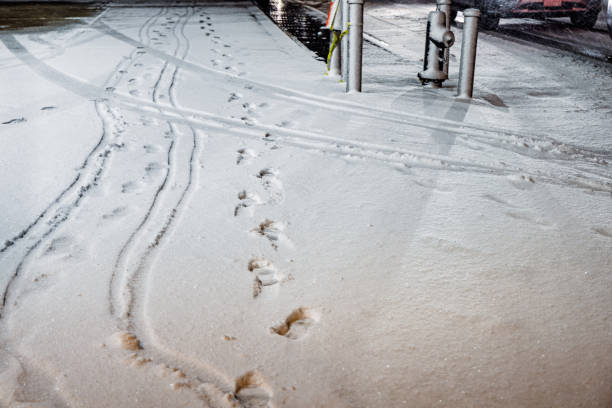Footsteps and a fire hydrant in freshly fallen snow at nighttime in Queens in New York