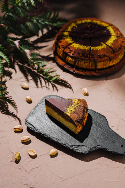 istock Delightful slice of layered cake served on a rustic black slate board with decorative green leaves in natural light 2197563853