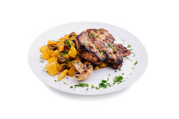 A platter of perfectly grilled chicken is displayed alongside roasted potatoes and mushrooms, garnished with fresh herbs for an appetizing look.