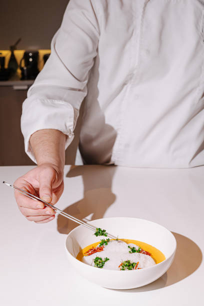 istock Culinary artist plating a gourmet dish with precision in a modern kitchen at twilight 2197564116