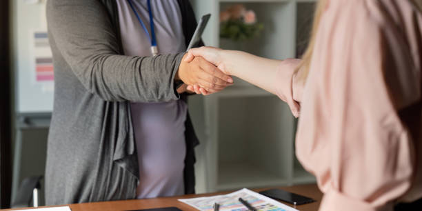 istock Graphic designers shaking hands in a welcoming office environment. 2197564758