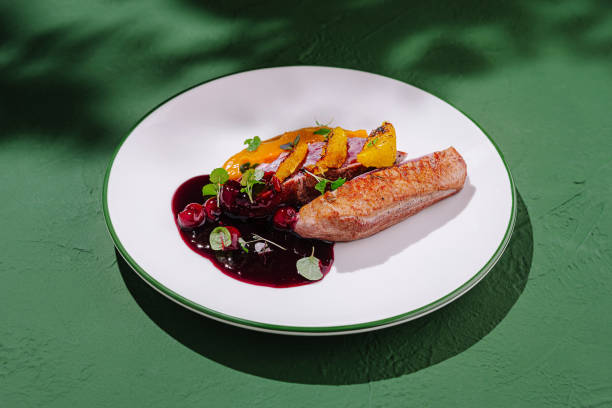 istock Culinary masterpiece featuring roasted duck breast with berry sauce and citrus garnish served on white plate 2197567345