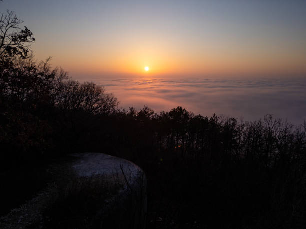 istock A stunning sunrise over a misty mountain landscape, with golden light illuminating rolling clouds. The serene atmosphere blends forest silhouettes with soft morning hues, creating a breathtaking panoramic view 2197570219