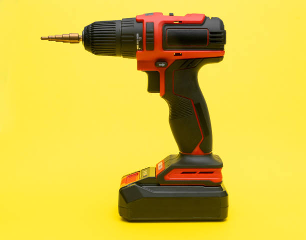 istock Cordless screwdriver with a drill for metal on a yellow background. 2197571371