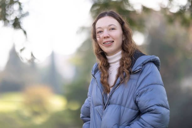 istock Happy student wearing dental braces is posing in a park during winter 2197572730