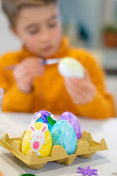 istock Child painting easter eggs at home: getting ready for easter festivities 2197574945