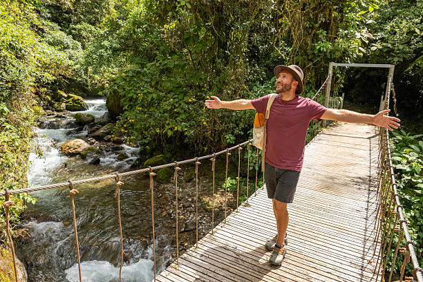 istock Traveler on Scenic Jungle Bridge Admiring River View 2197575136