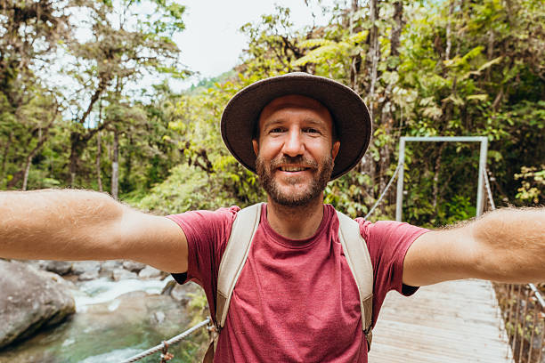 istock Man Taking Selfie on Scenic Jungle Bridge 2197575148