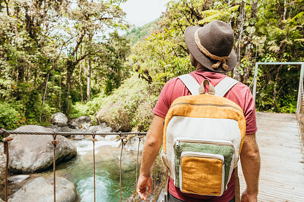 istock Man Enjoying a Scenic Walk on Forest Bridge 2197575154