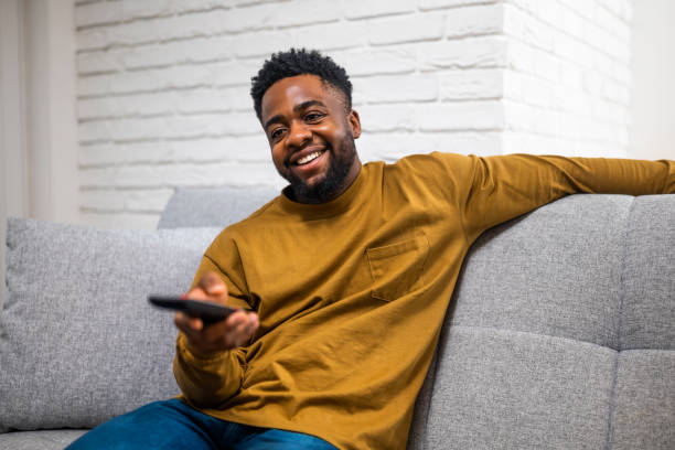 istock Relaxed black man watching tv at home 2197575577