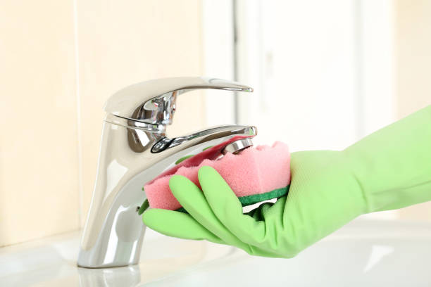 istock Hand in glove cleaning water tap in bathroom 2197575583