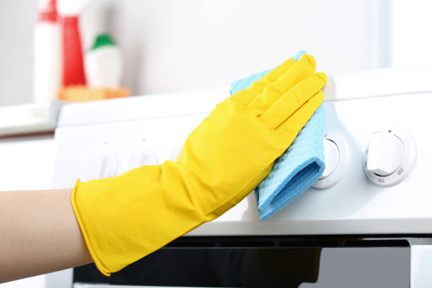 istock Hand in glove with sponge cleaning electric stove 2197575868