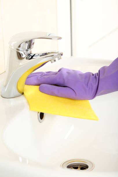 istock Hand in glove cleaning water tap in bathroom 2197576112
